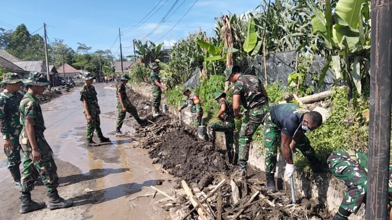 Personel Gabungan Kodim 0821 dan Yonif 527/BY Bersihkan Selokan di Jalur Vital Supiturang