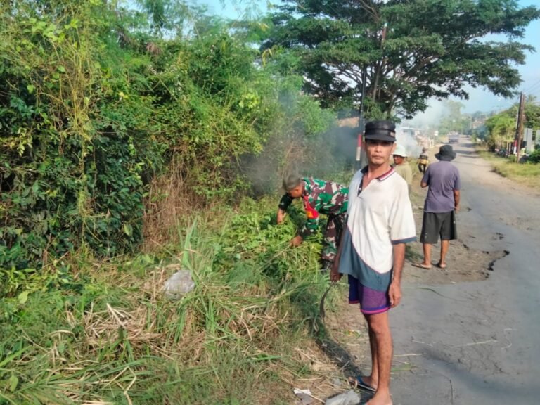 Babinsa Koramil Pesanggaran Kerja Bakti Bersihkan Ruas Jalan Desa Untuk Peduli Kebersihan Lingkungan